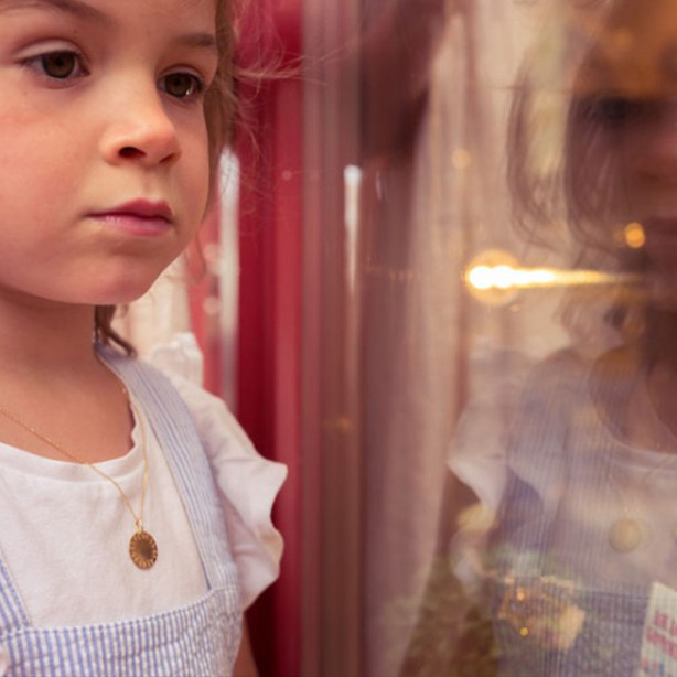 Médaille de baptême en or jaune 750 millièmes, portée par une enfant.
